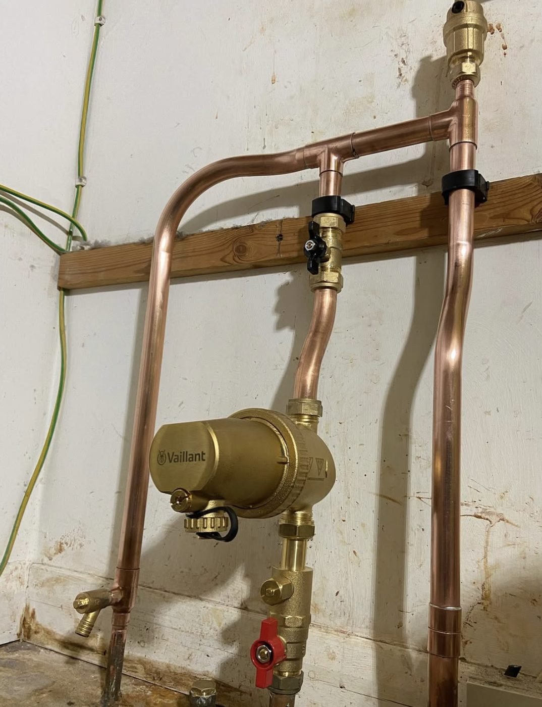 Vaillant heating pump with brass isolation valves and copper pipework in a cellar