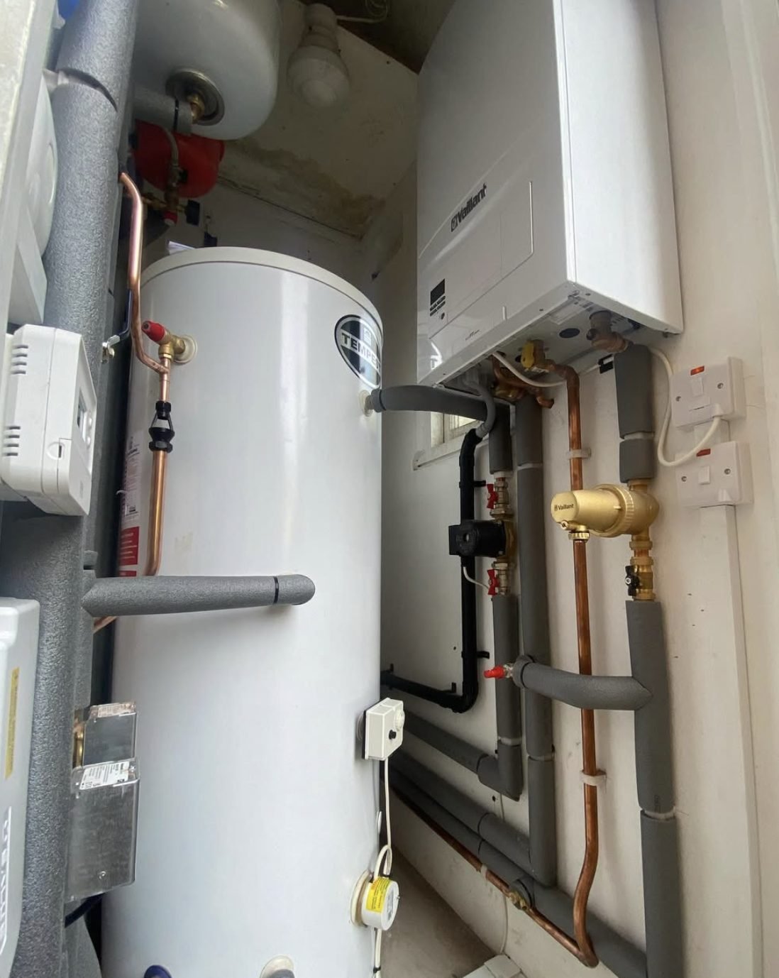 Vaillant system boiler beside a Tempest unvented hot water cylinder with insulated pipework